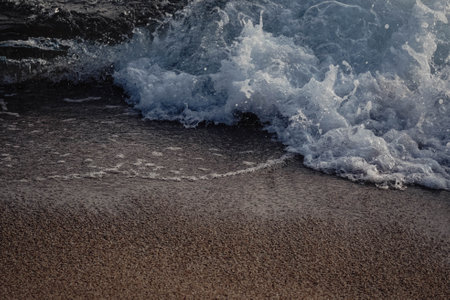 Landscape of a beach shore with waves and foamの写真素材