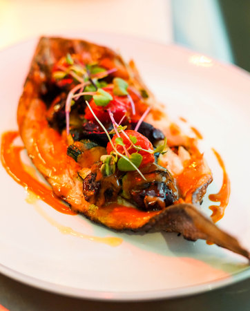 Dish of baked bream with vegetables in a gourmet restaurantの写真素材