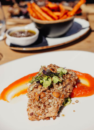 Fried meat with vegetables on a white plate in a restaurant.の写真素材