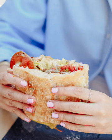 A young person enjoying a beef sandwichの写真素材