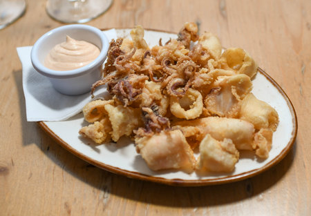 A serving of fried squid with garlic sauce in a European restaurantの写真素材