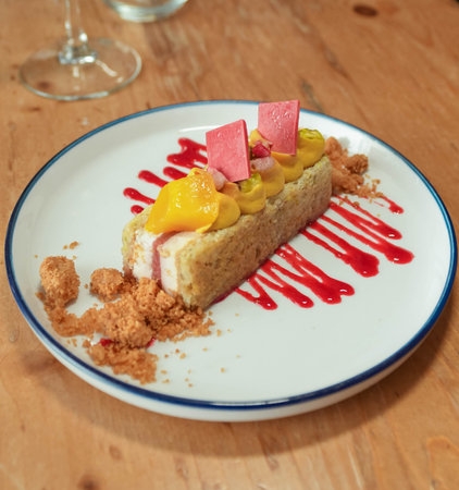Strawberry cake on a white plate on a wooden table.の写真素材