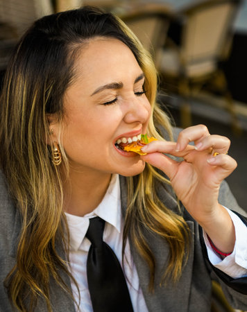 Young woman eating nachos with cheese in a restaurant. Fast food concept.