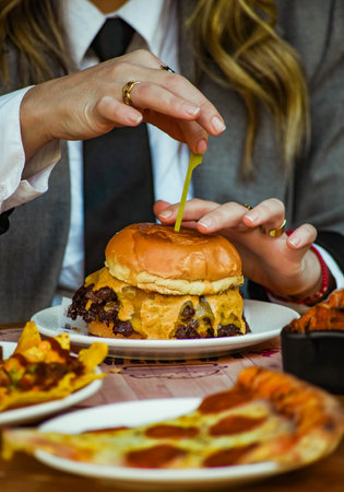 A young businesswoman eating a burger at an outdoor cafeの写真素材