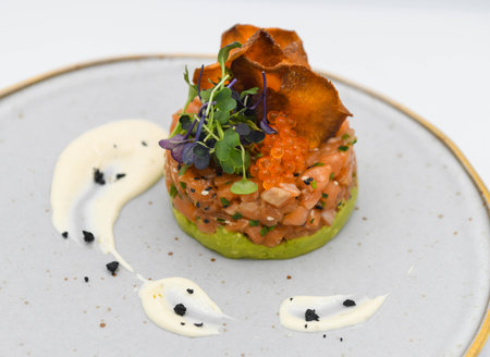 salmon tartare with avocado and salmon caviar on white backgroundの写真素材