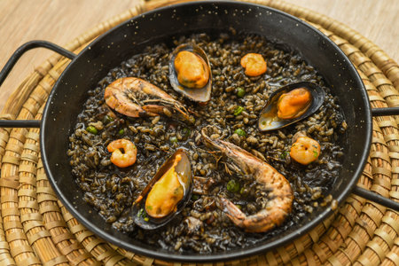 Paella with mussels on a wooden tableの写真素材
