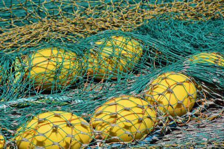 Fishing net and buoys spread out on the groundの写真素材
