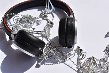 Headphones and silver Christmas decoration on white background.
