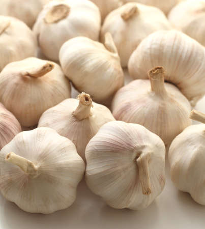 Pile of fresh white garlic on a white backgroundの写真素材