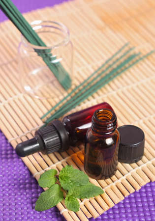 Bottles of essential oil and mint leavesの写真素材