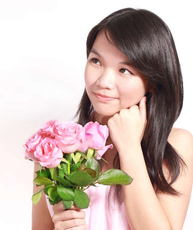 A beautiful and sweet Asian lady holding a bunch of rosesの写真素材