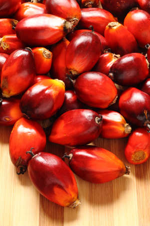 a bunch of oil palm fruits on a timber background