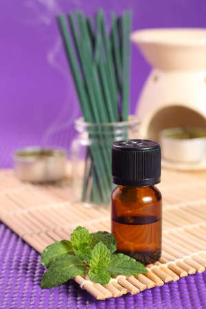 Bottle of essential oil, mint leaves and candles  Letの写真素材