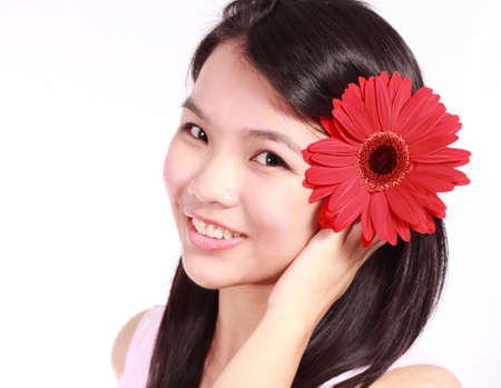 Beautiful young lady with gerbera flower isolated on white background の写真素材