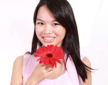 Beautiful young lady with gerbera flower isolated on white background の写真素材