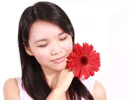 Beautiful young lady with gerbera flower isolated on white background の写真素材