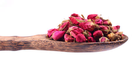 Dried roses flowers in a wooden scoop on a white backgroundの写真素材