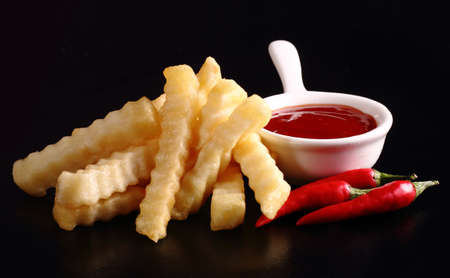 French fries, chili and chili sauce on black color backgroundの写真素材