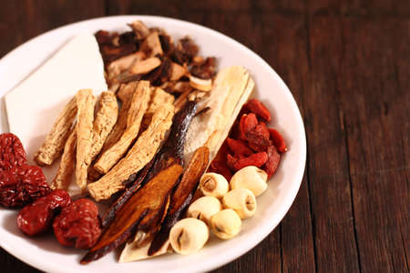 Traditional Chinese Herbal Medicine in plate on wooden backgroundの写真素材