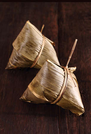 Two traditional homemade chinese rice dumplings on brown color backgroundの写真素材