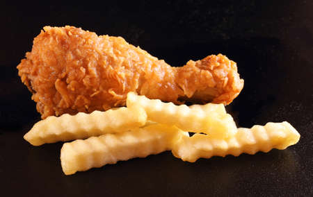 Fried chicken and french fries isolated on black color backgroundの写真素材