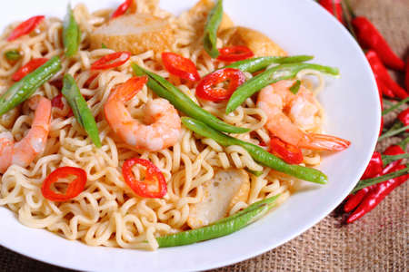 Hot and spicy fried noodle and ingredients on the sack background