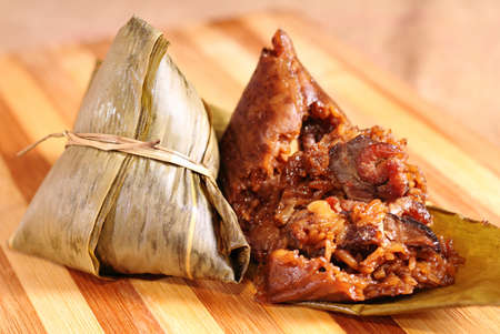 Two traditional homemade chinese rice dumplings on yellow wooden backgroundの写真素材