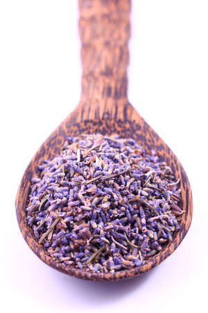 Dried lavender flowers in a wooden scoop isolated on white の写真素材