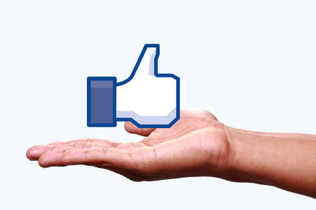 Johor, Malaysia - Jun 24, 2014: Hand showing a like icon. Like icon button is the voting system used to rate user comments on Facebook, Jun 24, 2014 in Johor, Malaysia.のeditorial素材