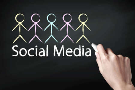 Hand holding a chalk and drawing social media iconの写真素材