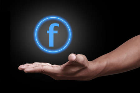 Hand showing blue f iconのeditorial素材