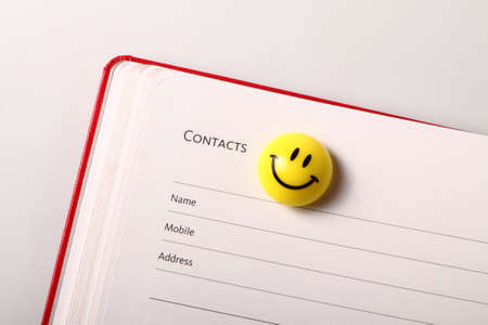 Contact book and smiley icon isolated on white backgroundの写真素材