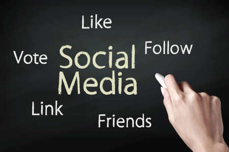 Hand holding a chalk and writing social mediaの写真素材