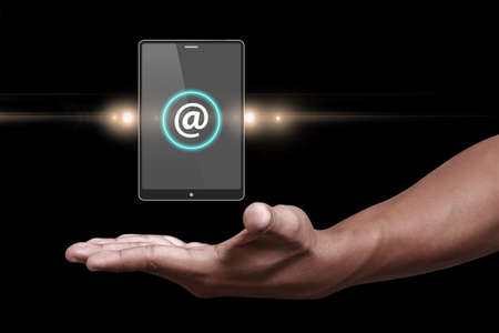 Hand showing at sign with smartphoneの写真素材