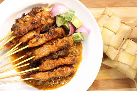 Satay is a Malaysian-style kebab. It is served with a peanut sauce, and slivers of cucumbers and onions.の写真素材