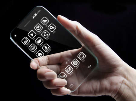 Hand and futuristic transparent smartphone isolated on black background. The most promising technologies in the mobile market is flexible and transparent displays.の写真素材