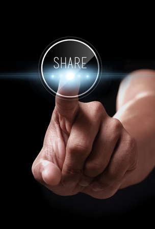 Hand pressing share icon on a virtual screenの写真素材