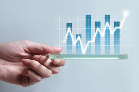 Hand showing blue business chart on smartphone, representing business growth. The background is...