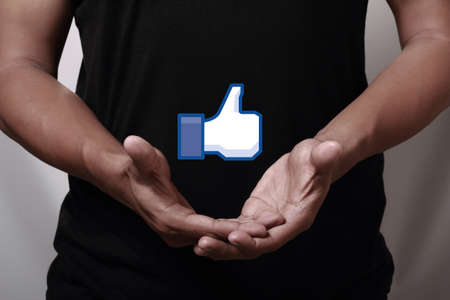 Johor, Malaysia - May 11, 2014: Hand showing a like icon. Like icon button is the voting system used to rate user comments on Facebook, May 11, 2014 in Johor, Malaysia.のeditorial素材