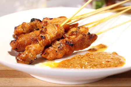 Satay is a Malaysian-style kebab. It is served with a peanut sauce, and slivers of cucumbers and onions.の写真素材