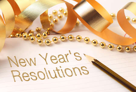 New Year's resolutions with gold color decorations. New Yearâ€™s resolutions are goals or...