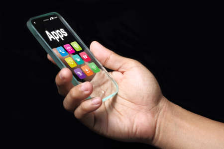 Transparent smartphone, apps with hand on dark background.の写真素材