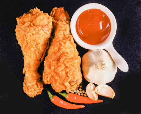 Hot and crispy fried chicken, chili, garlic and black pepper on black backgroundの写真素材