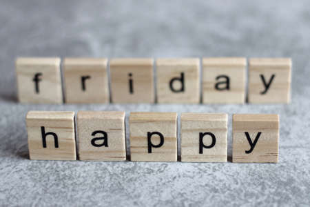 Happy friday word written on wood cube with gray background.の写真素材
