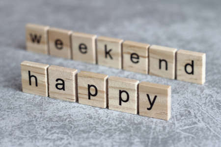 Happy weekend word written on wood cube with gray background.の写真素材