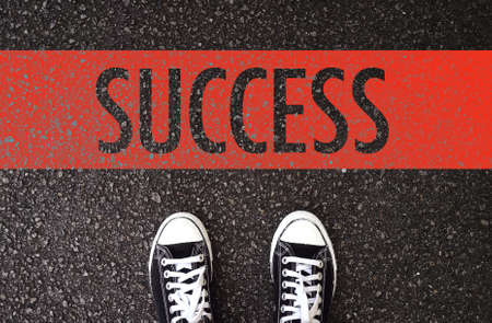 Black shoes standing at the road with success wording.の写真素材