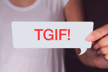 Hand holding white talk bubble and showing TGIF wording.の写真素材