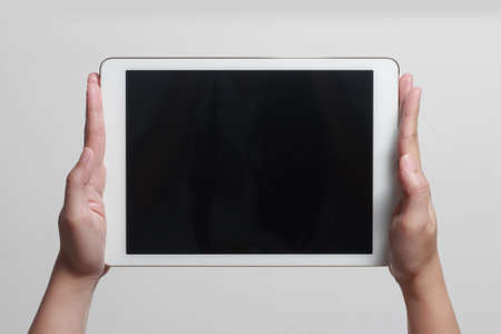 Hands showing tablet. A tablet is a wireless touch screen personal computer that is smaller than a...