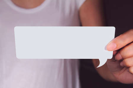 Hand holding white talk speech bubble with simple and clean background.の写真素材