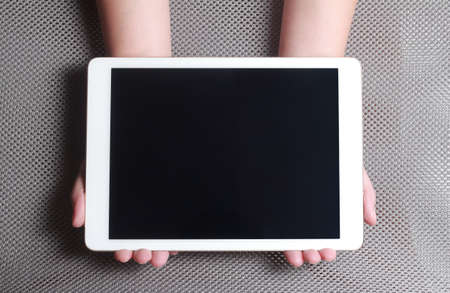 Hands showing tablet. A tablet is a wireless touch screen personal computer that is smaller than a notebook but larger than a smartphone.の写真素材